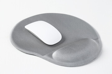 Mouse and mousepad with arm rest on white table, closeup