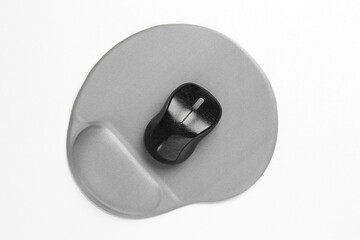 Computer mouse and mousepad with armrest on white table, top view