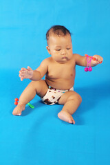 Adorable one year old Asian baby boy, playing lato lato style