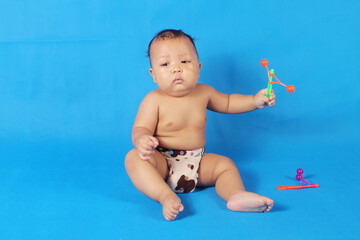 Adorable one year old Asian baby boy, playing lato lato style