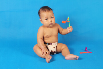 Adorable one year old Asian baby boy, playing lato lato style