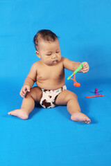 Adorable one year old Asian baby boy, playing lato lato style