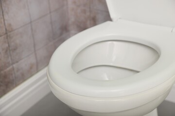 Toilet with clean seat in restroom, closeup