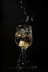 bebida alcohólica con dado dentro y salpicadura en fondo negro