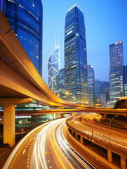 Urban skyline at dusk with illuminated skyscrapers and light trails from traffic.