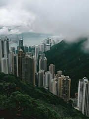 A misty view of a cityscape nestled between mountains and water.