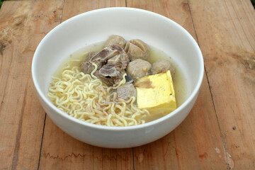 a bowl of meatballs and noodles and tofu and ribs
