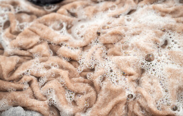 Cashmere Sweater Being Soaked and Washed in Delicate Soapy Water