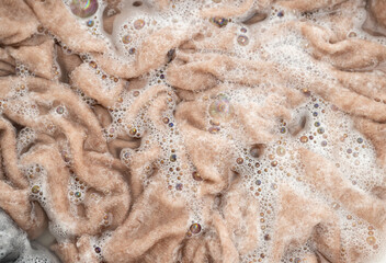 Cashmere Sweater Being Soaked and Washed in Delicate Soapy Water