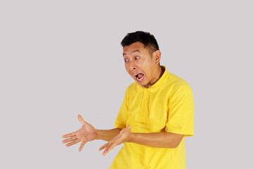 An Asian adult man opens his arms with a surprised expression.