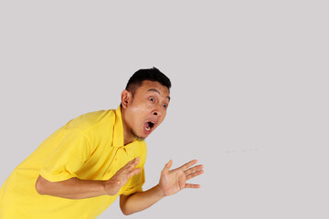 An Asian adult man opens his arms with a surprised expression.
