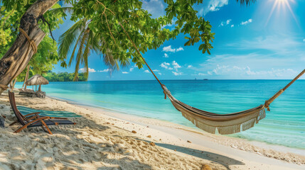 Fototapeta premium Tropical beach with hammock and palm trees by turquoise water