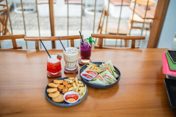 food and drinks served on wooden tables in a cafe