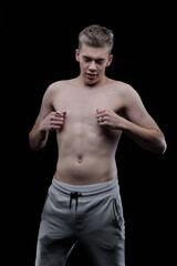 Fototapeta premium Young man posing in the dark in the studio