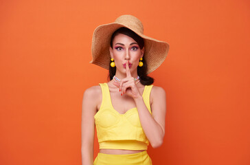 Happy young sexy woman slim body wear yellow swimsuit straw wide brim hat posing isolated on orange color background studio. Summer hotel pool sea rest sun tan concept