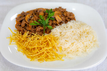 Traditional filet mignon stroganoff with mushrooms, French fries and rice
