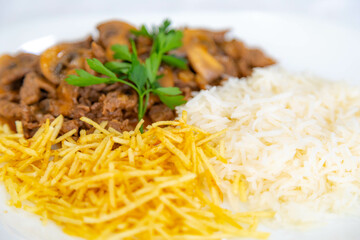 Traditional filet mignon stroganoff with mushrooms, French fries and rice