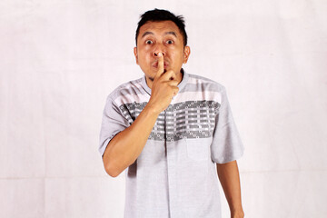 Mature Asian man covers his entire mouth with his hand
