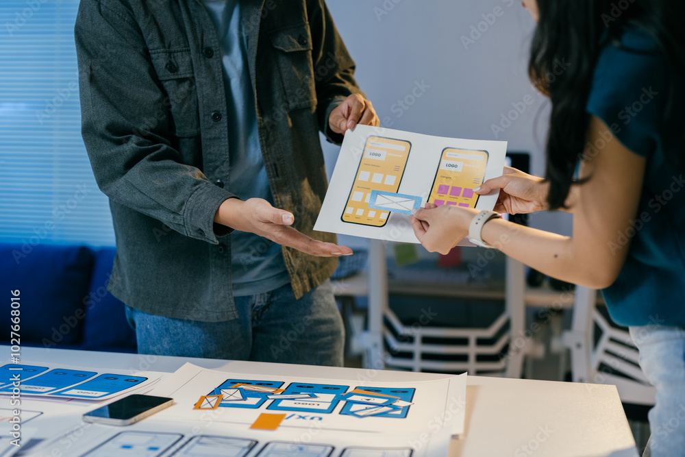 Poster Team of ui/ux designers collaborate on a mobile app wireframe, brainstorming in their office for a user-friendly design
