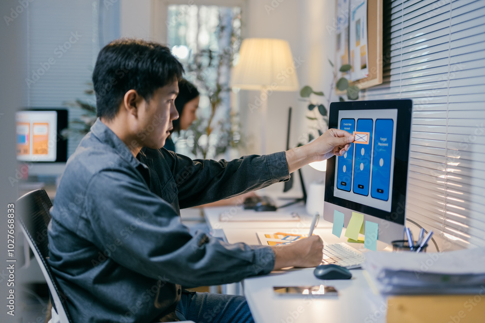 Poster Focused ui designer analyzes a mobile app on a computer, creating a user-friendly interface in a modern workspace