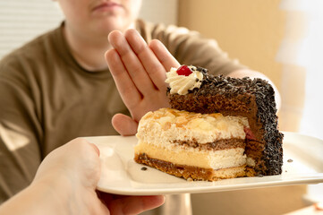 The person refuses the plate of desserts offered to them.