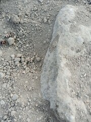 big stone with pebbles and sand around