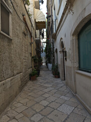 Obraz premium Narrow street in the old town center. Architecture of historic tenement houses in the Italian city. Bari, Puglia, Italy.