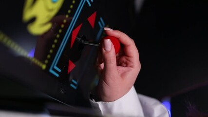 Woman playing arcade machine, female hand moving joystick close-up. Hands of a woman gamer playing an old arcade game and moving joystick. Games, hobby, old school, entertainment, retro video game.