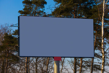 Billboard along the road and highway on a winter snow day. Background for design and advertising. 