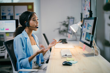 Focused businesswoman in video call at modern office, analyzing data and explaining information online. Illustrates importance of technology in corporate world