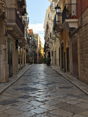 Fototapeta premium Narrow street in the old town center. Architecture of historic tenement houses in the Italian city. Bari, Puglia, Italy.