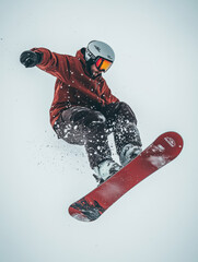 Snowboarder Performing Stunt in Mid-Air with Red Gear