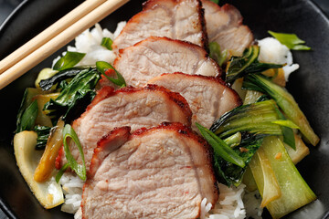 Chinese BBQ Pork Char Siu with rice and bok choy in a black bowl