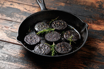 Black pudding or blood sausage with rosemary on a iron cast pan