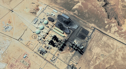 The landscape of a sandy desert and an oil plant in Qatar from a bird's eye view