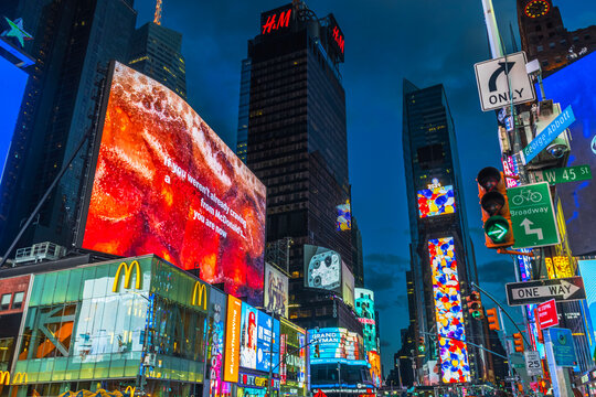 Times Square with McDonald's and H&M billboards lighting up the night sky, vibrant city scene in New York. USA.
