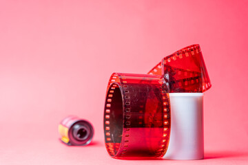 Red Film Strip Unwinding on Pink Background