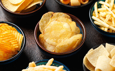 Set of different crispy potato chips in bowls. Snack food