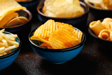 Set of different crispy potato chips in bowls. Snack food
