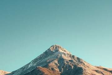 A solitary mountain peak against a clear blue sky - Powered by Adobe