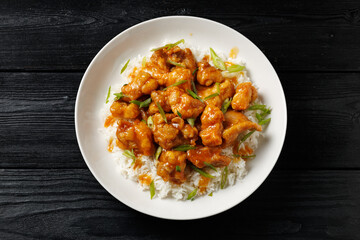 Chinese orange chicken with rice and green onion garnish