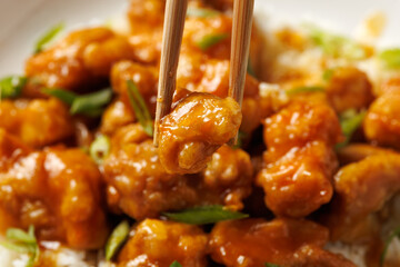 Chinese orange chicken with rice and green onion garnish