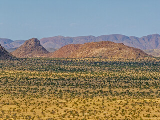 Desert landscape with ed granite hills around the Brandberg Mountain, nearby Uis city, Namibia