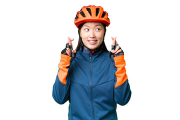 Young cyclist woman over isolated chroma key background with fingers crossing