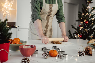 unrecognizable man preparing homemade gingerbread cookies for christmas