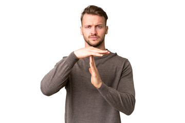 Young handsome caucasian man over isolated chroma key background making time out gesture