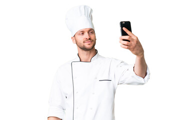 Young caucasian chef over isolated chroma key background making a selfie