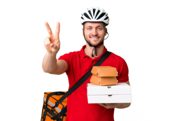 Young delivery man taking a takeaway food over isolated chroma key background smiling and showing victory sign