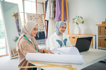 Obraz premium In a vibrant studio, two designers brainstorm while creating sketches and designs