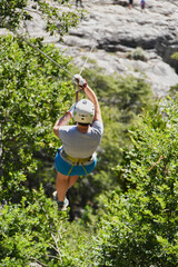 woman sliding on a zip line in a forest in the Andes Mountains in southern Chile